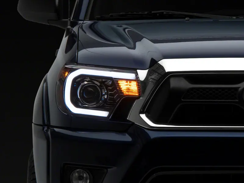 Raxiom Projector Headlight Assembly For 2012–2015 Toyota Tacoma – Black Housing, Clear Lens, Integrated Sequential Led Bar 1